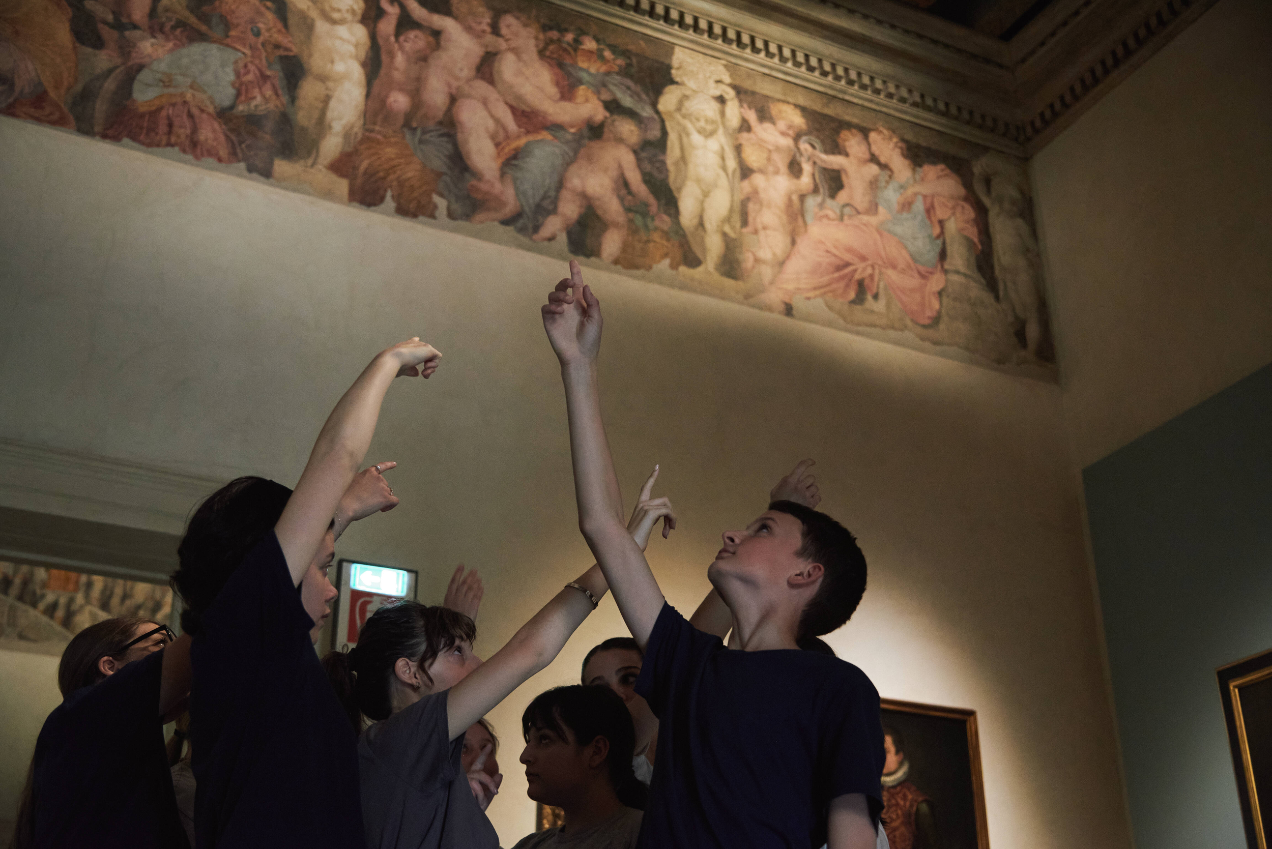 Giovani danzatori indicano gli affreschi nel museo in cui si muovono